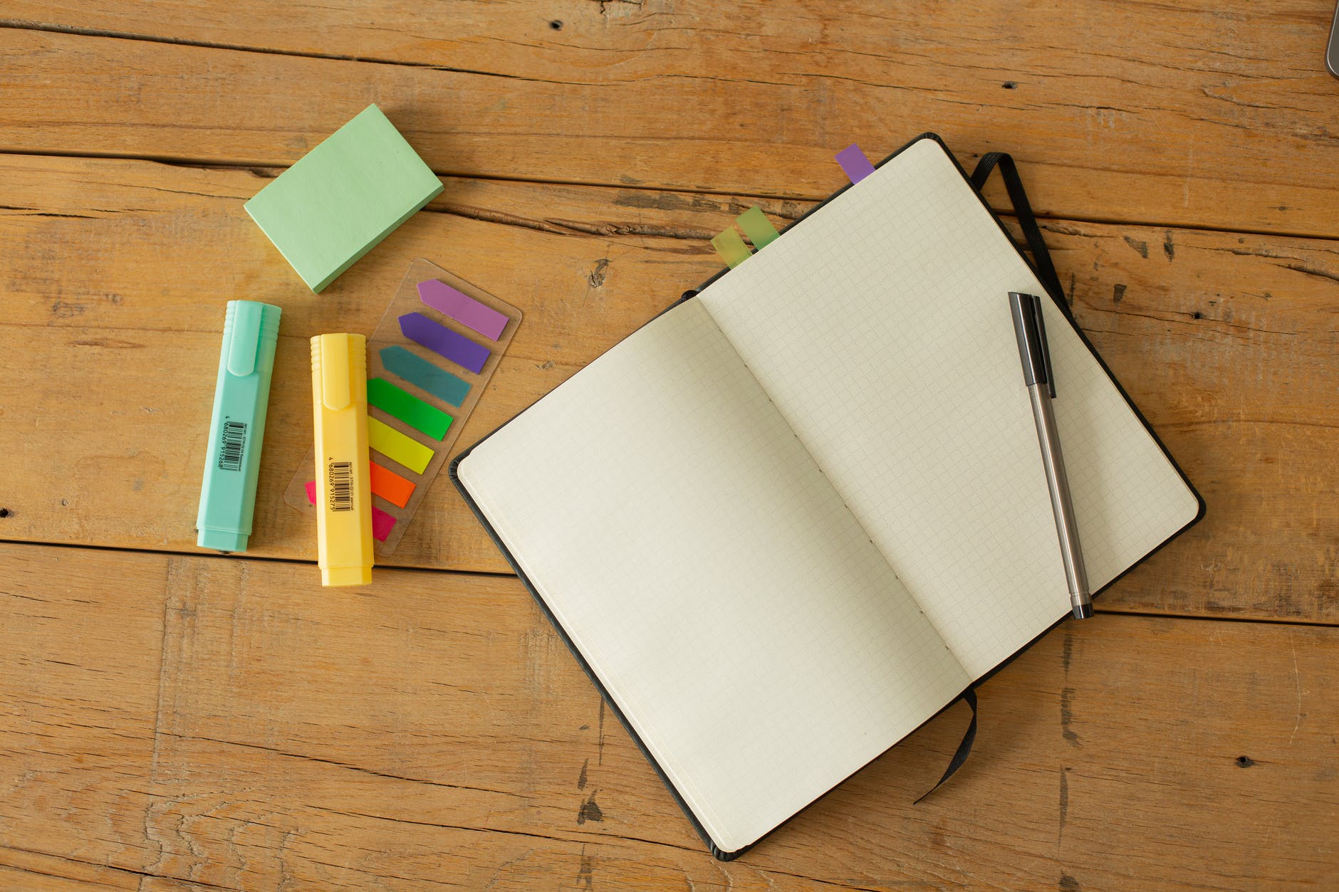 opened notebook with white blank pages and pen on table